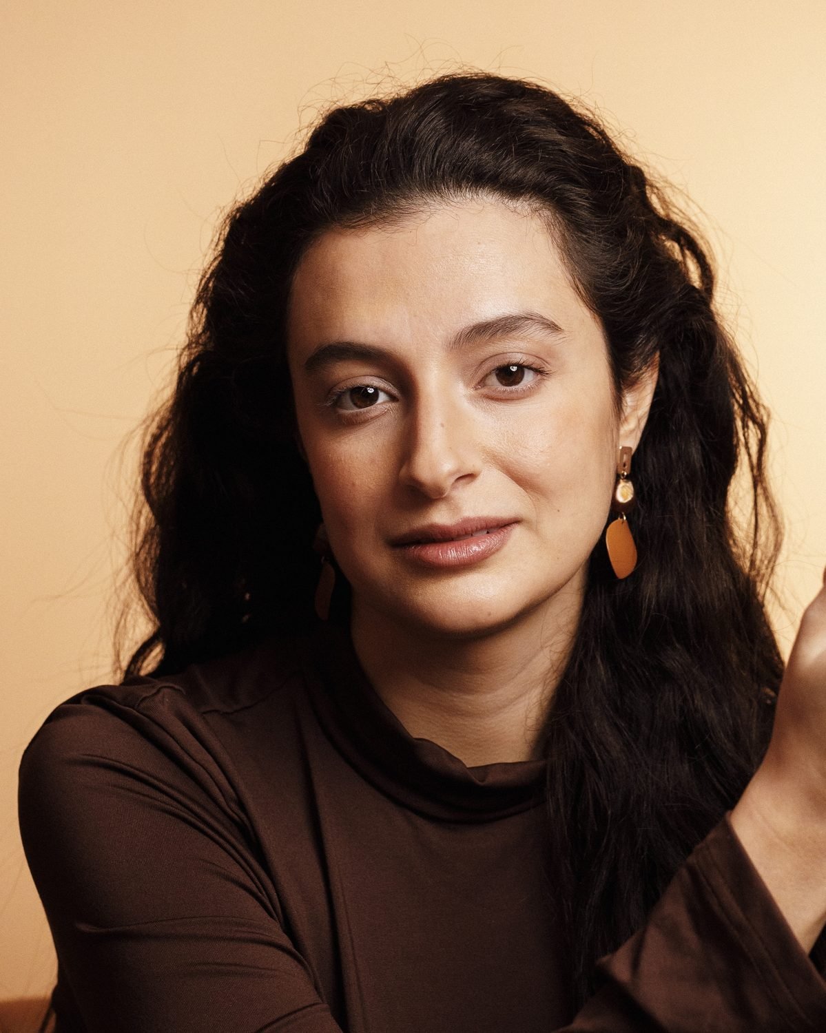 Isabelle Zighondi, ritratto su fondo ocra, capelli lunghi